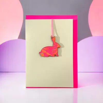 Cartão creme com base fúcsia e coelho pendurado rosa e laranja