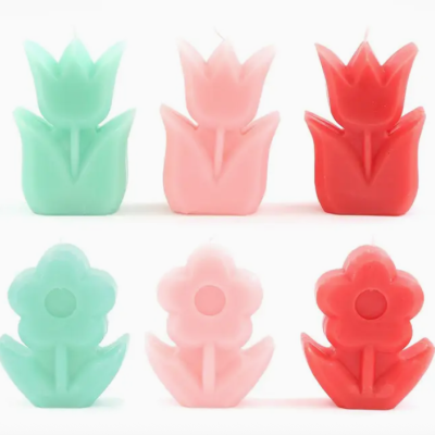 Seis sabonetes coloridos em forma de flor em verde, rosa e vermelho sobre fundo branco