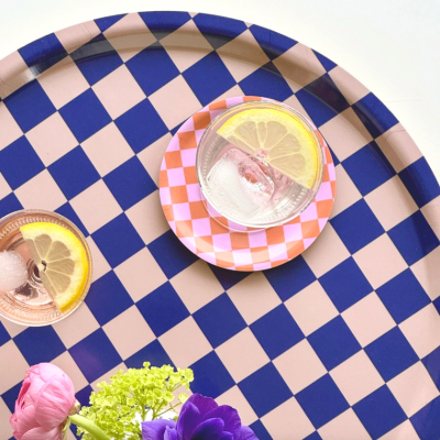 Tabuleiro redondo azul e rosa com bebidas e flores