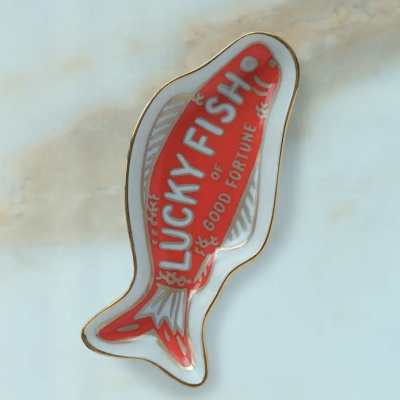 Prato cerâmico em forma de peixe com texto decorativo vermelho e branco