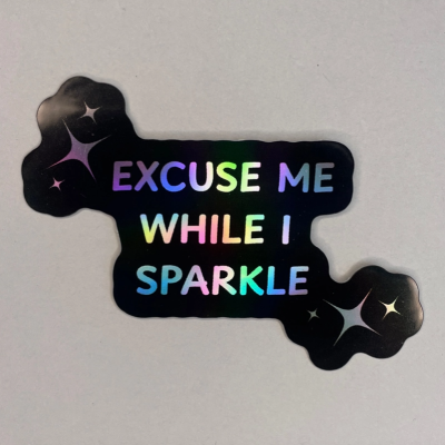 Autocolante preto holográfico com texto colorido EXCUSE ME WHILE I SPARKLE e desenhos de brilhos
