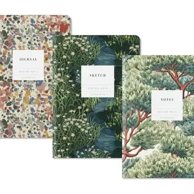 Três cadernos com capas decorativas e textos JOURNAL, SKETCH, NOTES.
