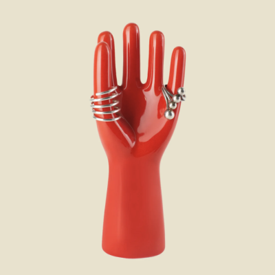 Mão vermelha exibindo dois anéis prateados