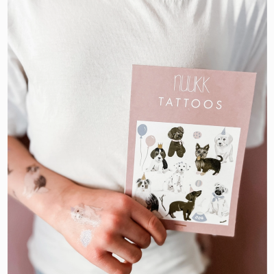 Pessoa a segurar cartaz cor-de-rosa com tatuagens temporárias de cães