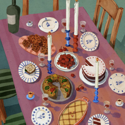 Mesa com velas, pratos azuis, bolos, doces e garrafa verde