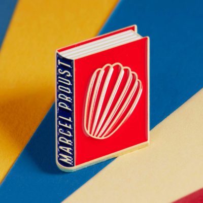 Pin metálico de livro vermelho e azul com concha em relevo