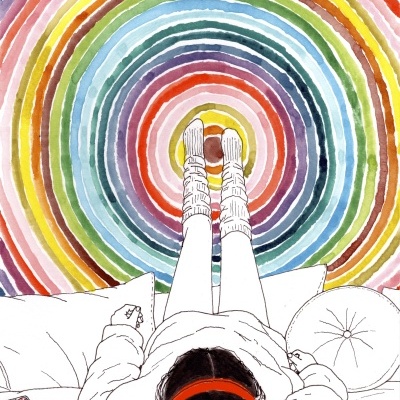 Pessoa deitada com auriculares vermelhos sobre tapete multicolor em círculos