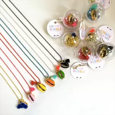 Conjunto de colares coloridos com pendentes em forma de concha e embalagens redondas com etiqueta LUCKY BUBBLE