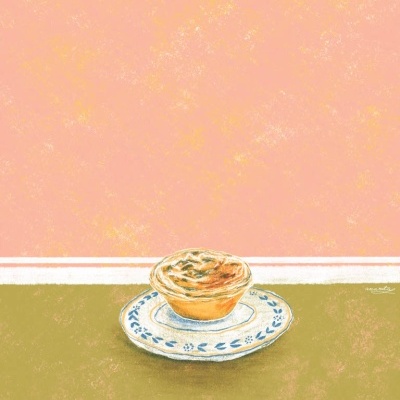 Tarte num prato de cerâmica com padrão azul sobre superfície verde e fundo rosa salmão