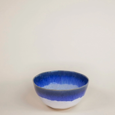 Taça de cerâmica azul e branca em fundo neutro