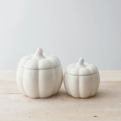 Frascos cerâmicos brancos em forma de abóboras de dois tamanhos diferentes sobre madeira clara
