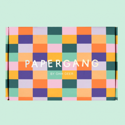 Caixa colorida com padrão quadriculado e texto PAPERGANG BY OHH DEER