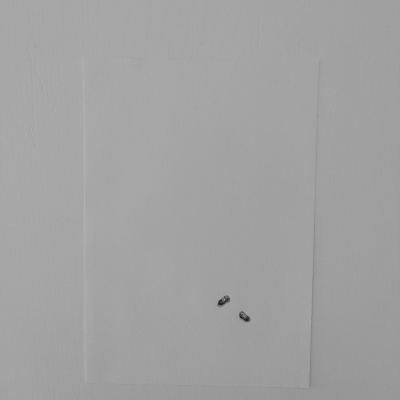 Folha branca presa à parede com dois grampinhos metálicos