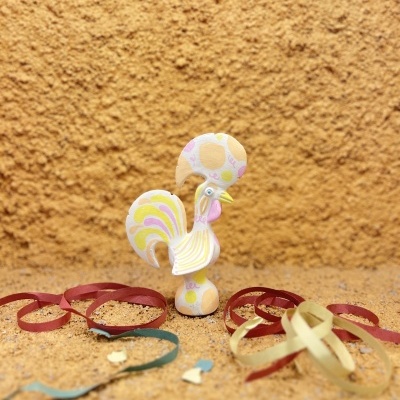 Escultura de galo em madeira com cores pastel e fitas decorativas coloridas