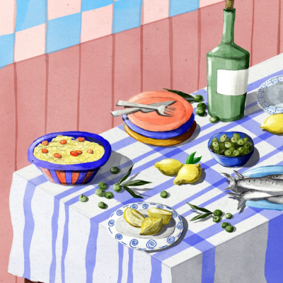 Mesa posta com diferentes pratos, limões, azeitonas e peixe sobre toalha listrada azul e branca.