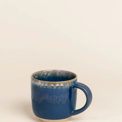 Caneca de cerâmica azul com padrão ondulado na parte superior