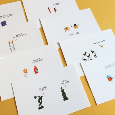 Cartões brancos com ilustrações coloridas e texto manuscrito em inglês sobre superfície amarela