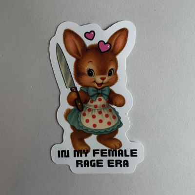 Autocolante de coelho castanho com avental e faca, texto IN MY FEMALE RAGE ERA