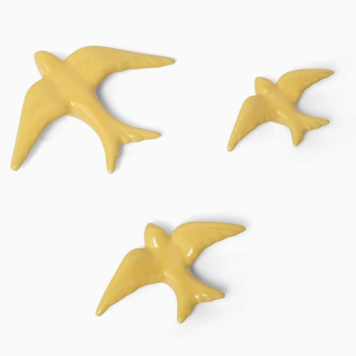 Figuras de pássaros em cerâmica amarela brilhante sobre fundo branco