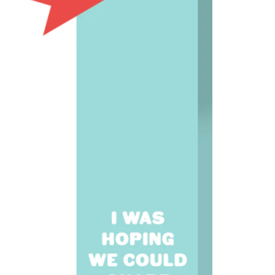 Saco de presente azul claro com alça e etiqueta vermelha e texto branco