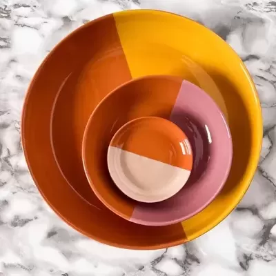 Conjunto de pratos coloridos empilhados sobre superfície de mármore