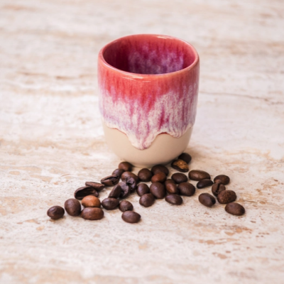 Copo cerâmico vermelho e creme com grãos de café