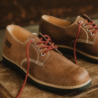 Sapatos castanhos de couro com atacadores vermelhos e costuras brancas, marcados com LOBO