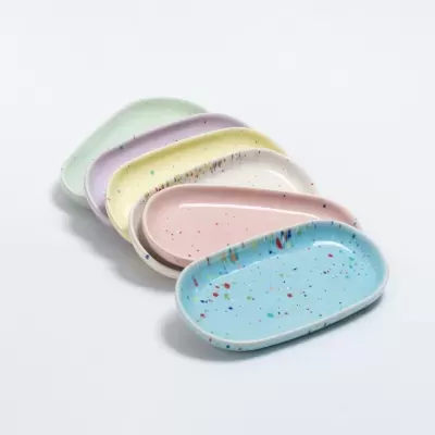 Conjunto de pratos ovais coloridos com padrão salpicado em fundo branco