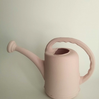 Regador de plástico rosa claro com bico longo e pega ergonómica