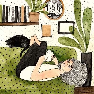 Mulher deitada no sofá verde com gato e plantas ao fundo