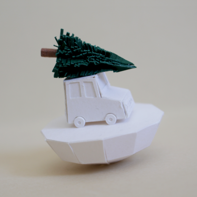 Miniatura branca de papel de carro a transportar árvore verde sobre base branca