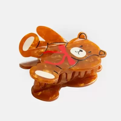 Penteado de cabelo em formato de urso castanho com laço vermelho
