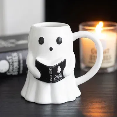 Caneca branca em forma de fantasma segurando um livro preto com texto