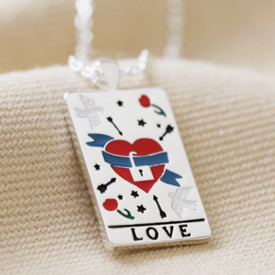 Pendente retangular prateado com coração vermelho, fita azul, pombas, setas, flores e a palavra LOVE