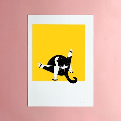 Ilustração de gato preto e branco sobre fundo amarelo em folha branca sobre superfície rosa