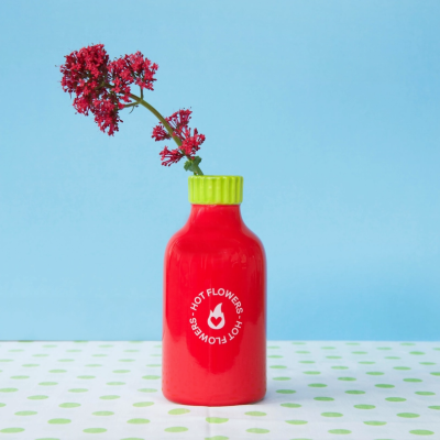 Frasco cerâmico vermelho com tampa verde e flores vermelhas