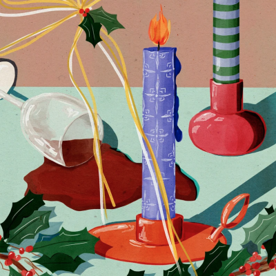 Duas velas decorativas, copo tombado com líquido vermelho e folhas de azevinho com bagas