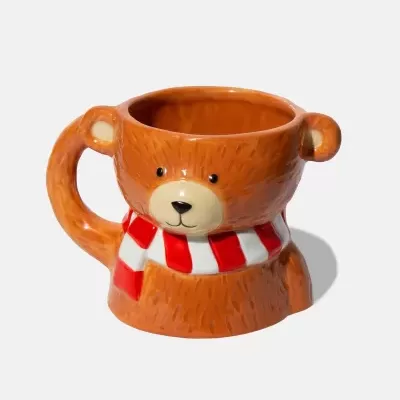 Caneca de cerâmica em forma de urso castanho com cachecol vermelho e branco.