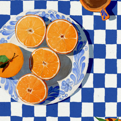 Prato com fatias de laranja numa toalha de mesa azul e branca, chávenas de café e laranjas com folhas.