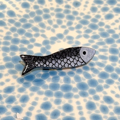 Prato de cerâmica azul com peixe decorativo cinza e preto