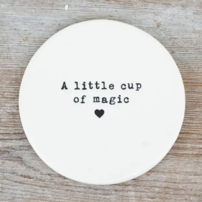 Prato redondo branco com texto A little cup of magic em preto