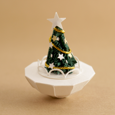 Miniatura de árvore de Natal verde com decoração branca e dourada numa base branca