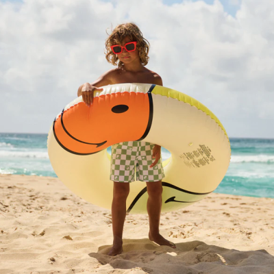 Criança com boia insuflável amarela na praia