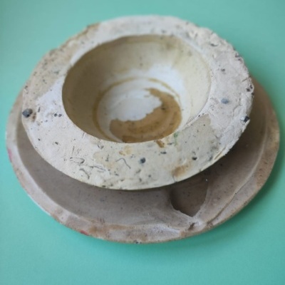 Dois pratos rústicos empilhados sobre fundo verde