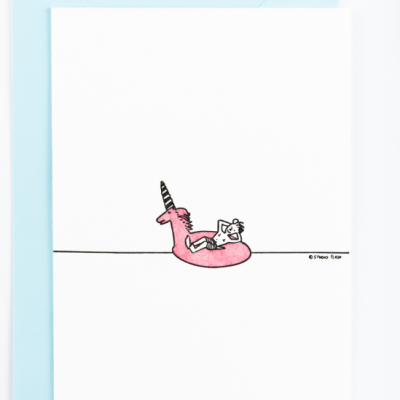 Cartão branco com desenho de boia unicórnio rosa e pessoa deitada, envelope azul