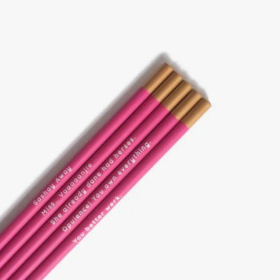 Cinco lápis cor-de-rosa com texto branco e extremidades douradas sobre fundo branco