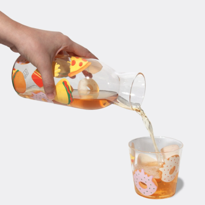 Garrafa e copo transparentes decorados com ilustrações de fast food e a bebida a ser servida.