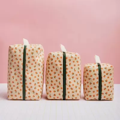 Três necessaires retangulares com padrão de laranjas e fecho verde escuro