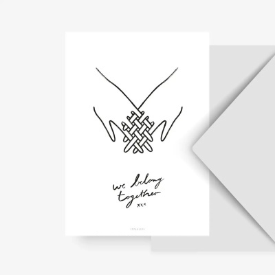 Cartão branco com desenho a preto de duas mãos entrelaçadas e texto manuscrito we belong together xxx
