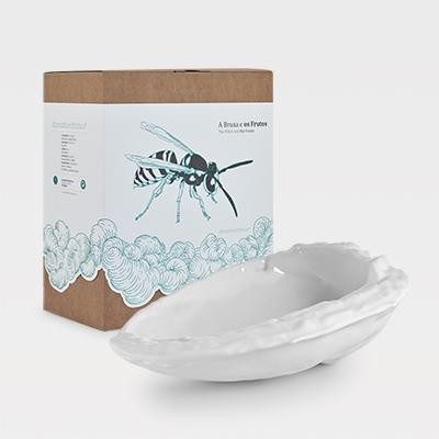 Vela decorativa branca em recipiente de cerâmica com embalagem ilustrada